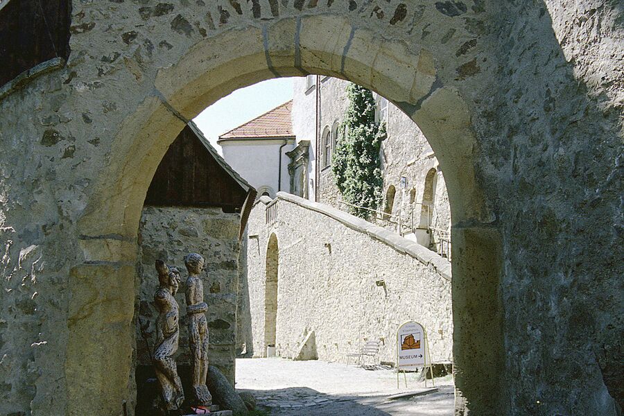 Farbfoto mit Blick von außen durch das weitgeöffnete Tor am Eulenturm in den unteren Schlosshof und auf die Reitertreppe