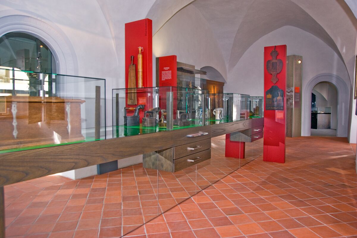 Blick in die neue Dauerausstellung zur Stadtgeschichte im Erdgeschoss: Informationsstelen in Rot und eine lange Tafel mit Exponaten.