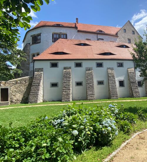 Blick auf das Schloss mit Vorburg und Stützpfeiler vom Rundweg im Garten
