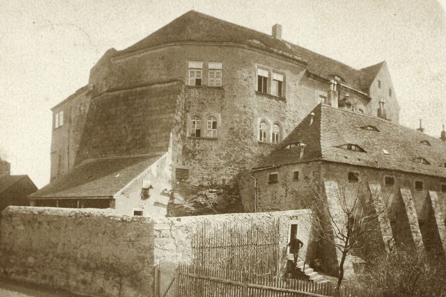 Schwarz-Weiß-Foto um 1900. Im Vordergrund sind die Mauern des Gefängnishofes und die Vorburg mit Stützmauern zu sehen. Dahinter ragt die Hauptburg.