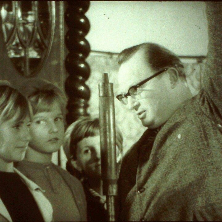 Rudolf Limpach im Gespräch mit Kindern auf einem monochromen historischen Foto