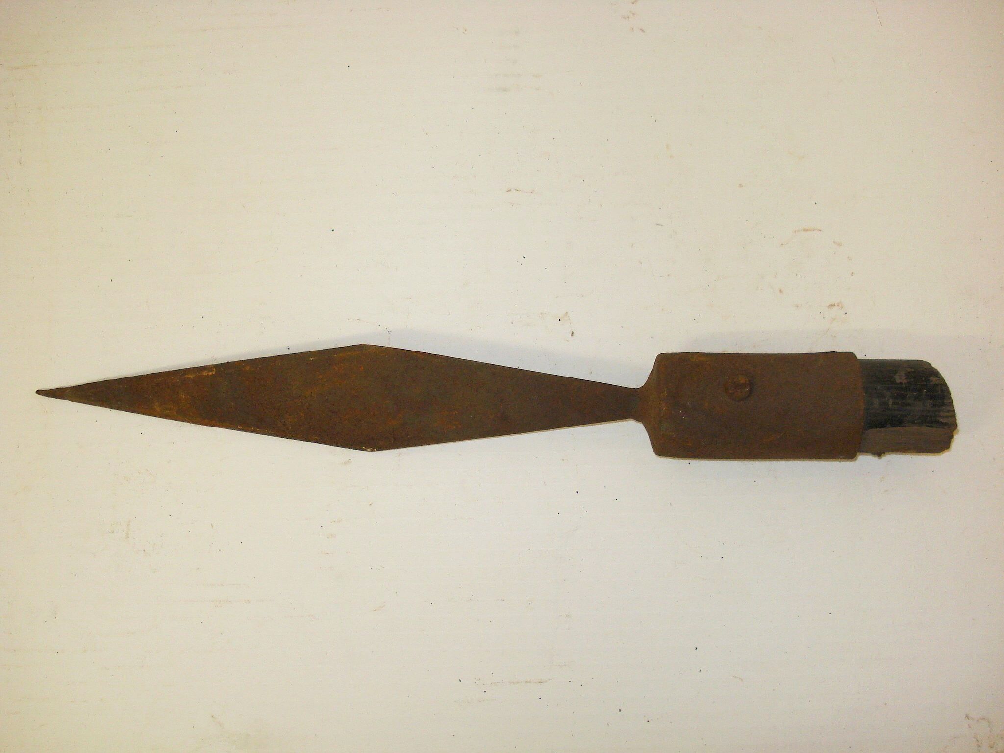 Lanzenspitze aus Eisen mit dem Rest eines abgesägten, schwarz lackiertem Holzstiels.
