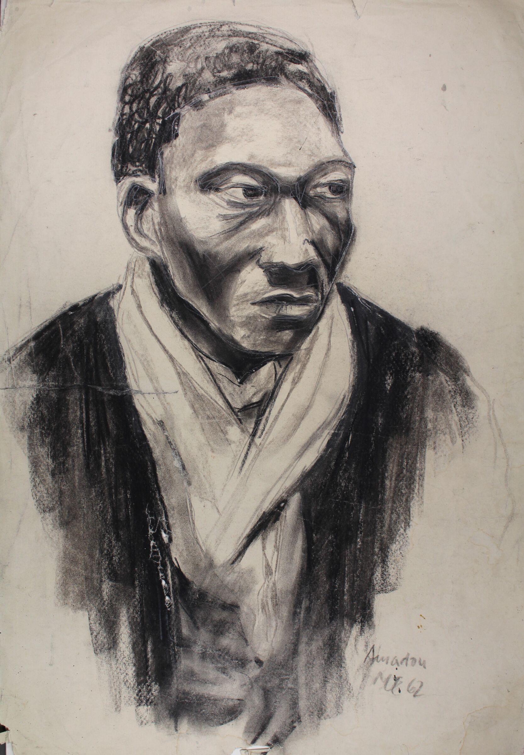 Die Kohlezeichnung zeigt einen vermutlich afrikanischstämmigen jungen Mann, der ernst leicht nach rechts blickt. Er hat ein helles Tuch umhängen und trägt ein dunkles Gewand.