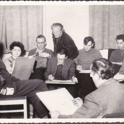 Eine Schwarzweißfotografie zeigt eine Gruppe junger Erwachsener beim Zeichnen. In der Mitte steht der Zirkelleiter Rosso Majores.