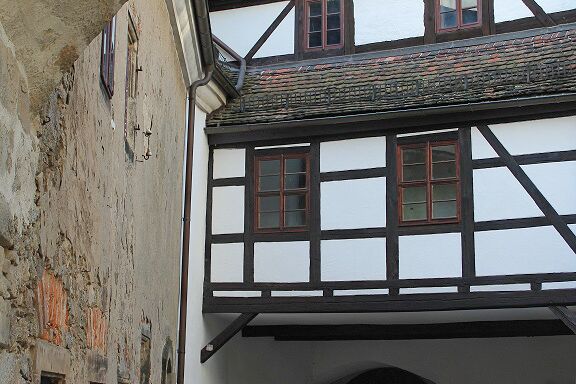 Links im Bild ist der noch unsanierte Teil des Amthauses mit bröckelnder Putzfassade. Frontal sieht man über dem Stadttor den Anschluss an die Vorburg. Dieses Fachwerkgebäudeteil ist saniert.