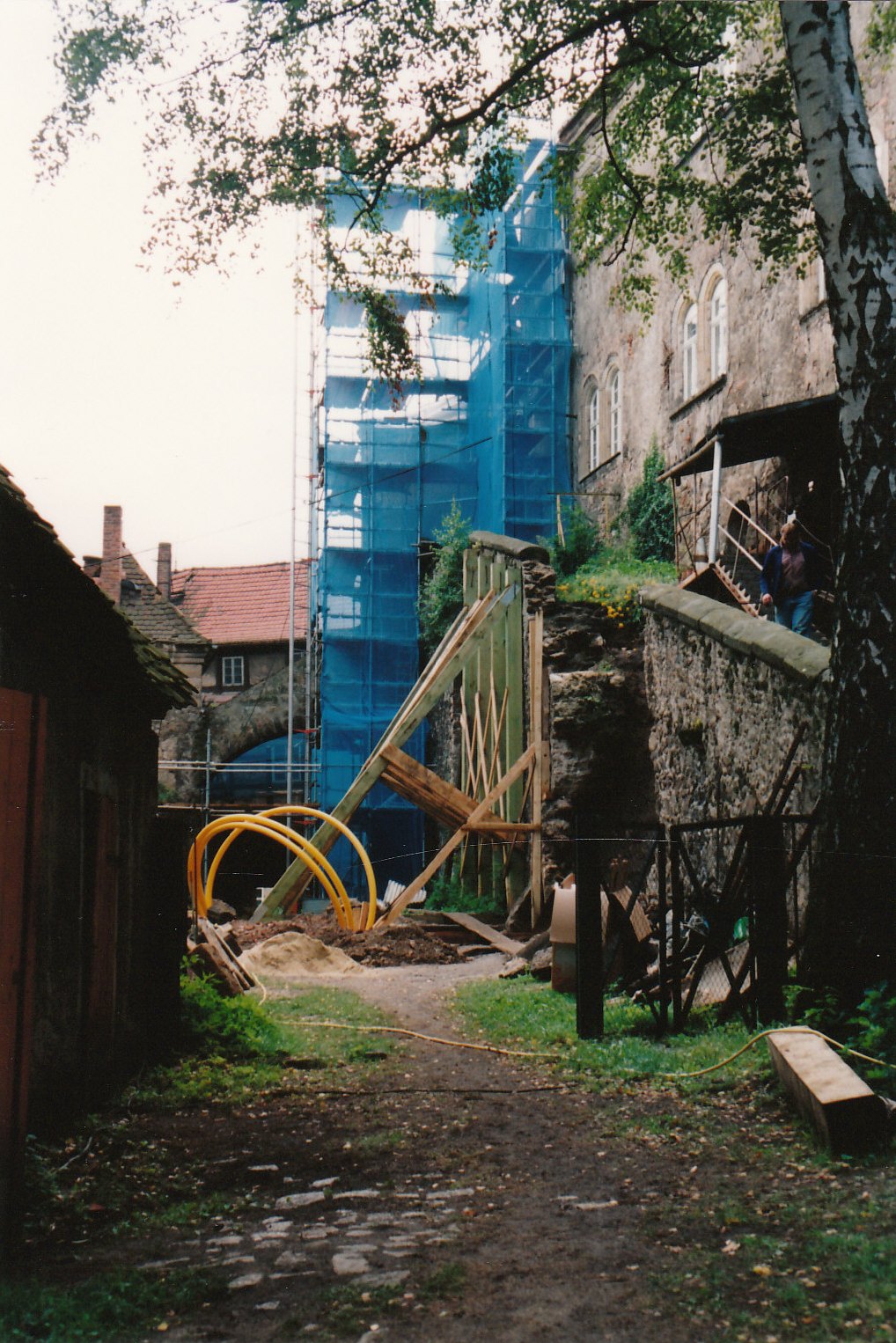 Blick in den unteren Schlosshof 1993. Die Fürstenreittreppe ist abgestützt, ein burghohes Gerüst steht im vorderen Teil. Der Boden ist in der Mitte freigelegt. Dort ragen große gelbe Kabel heraus.